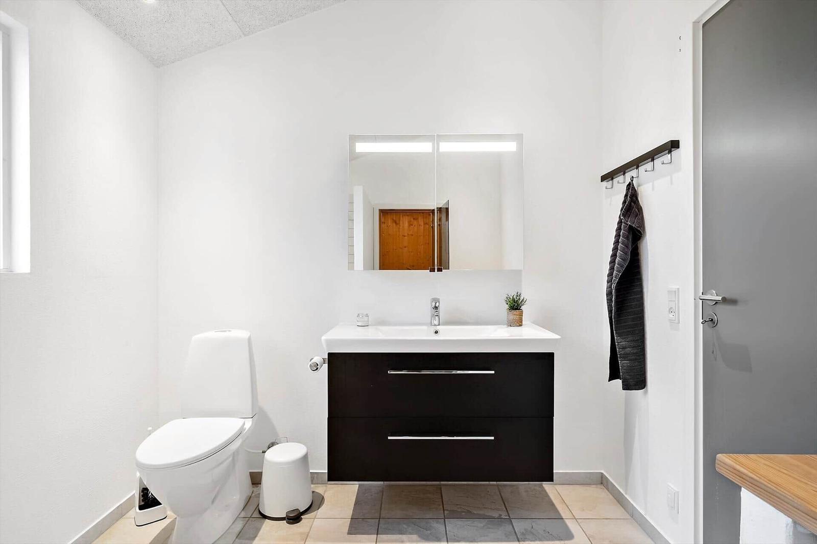 Badezimmer mit Toilette, Waschbecken und Spiegel