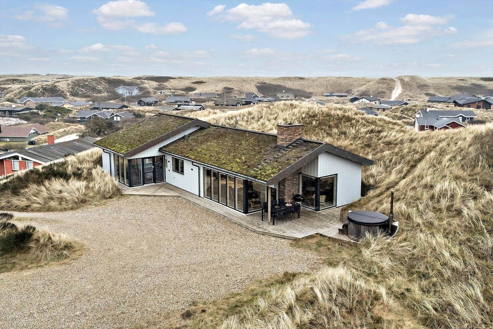 Moderne Villa mit Grasdach und Terrasse auf Dünenlage.