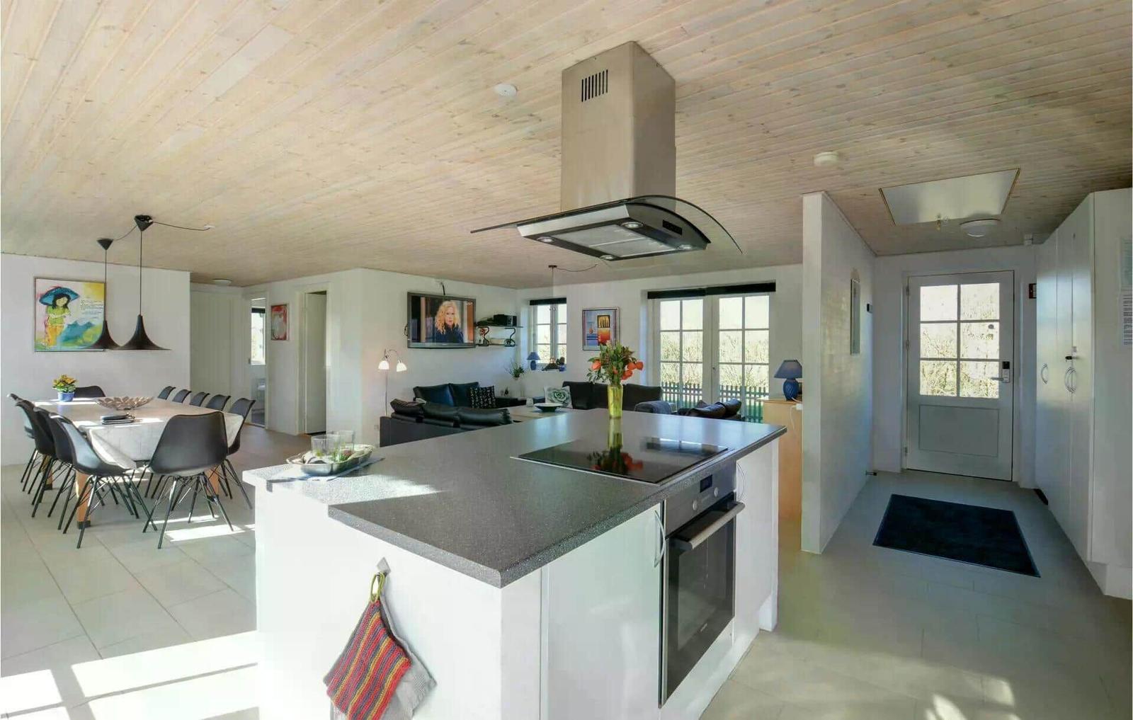 Küche mit Insel, Essbereich und Wohnzimmer im offenen Grundriss.