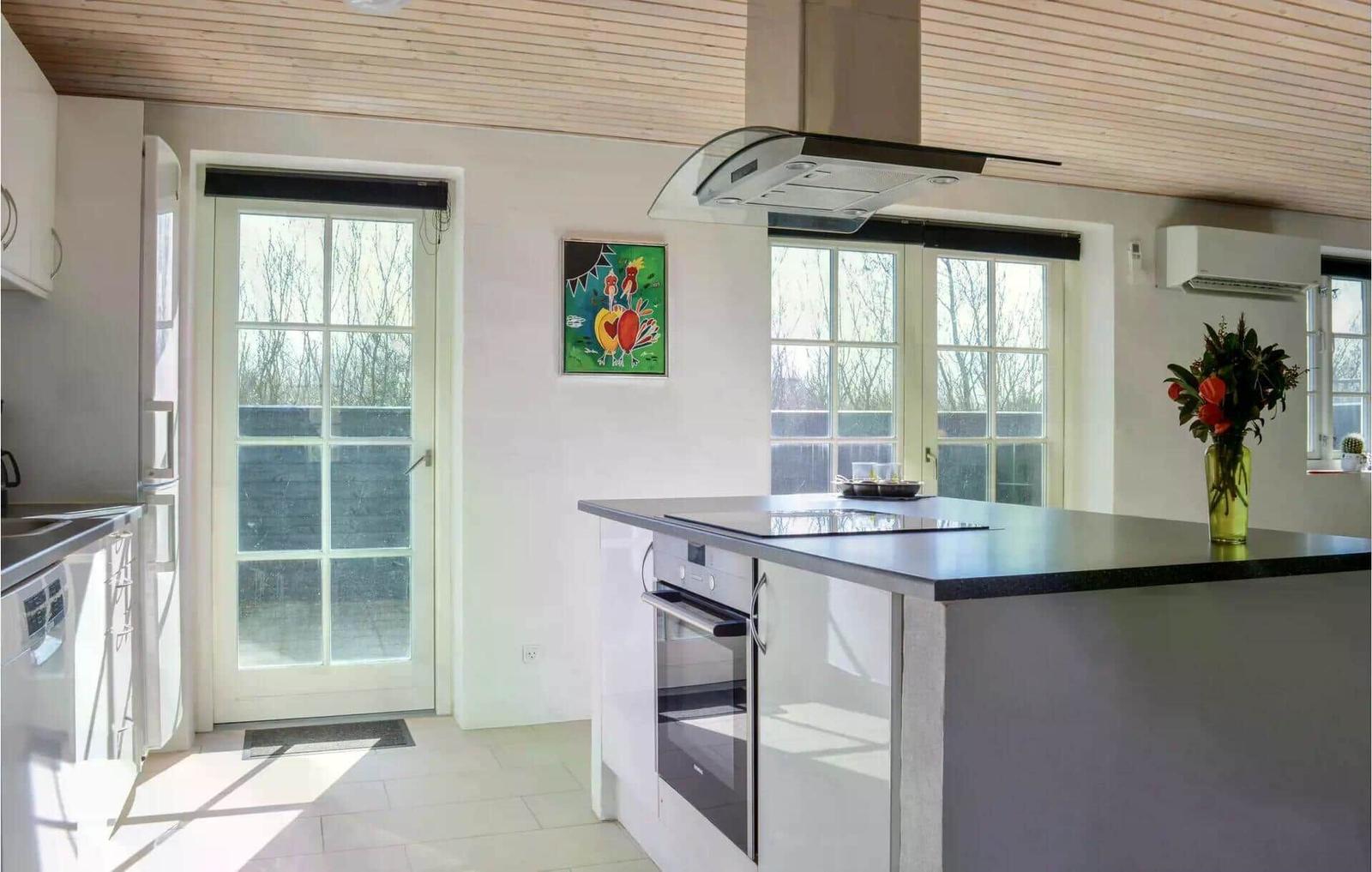 Küche mit Kücheninsel, Fenster und Haushaltsgeräten.