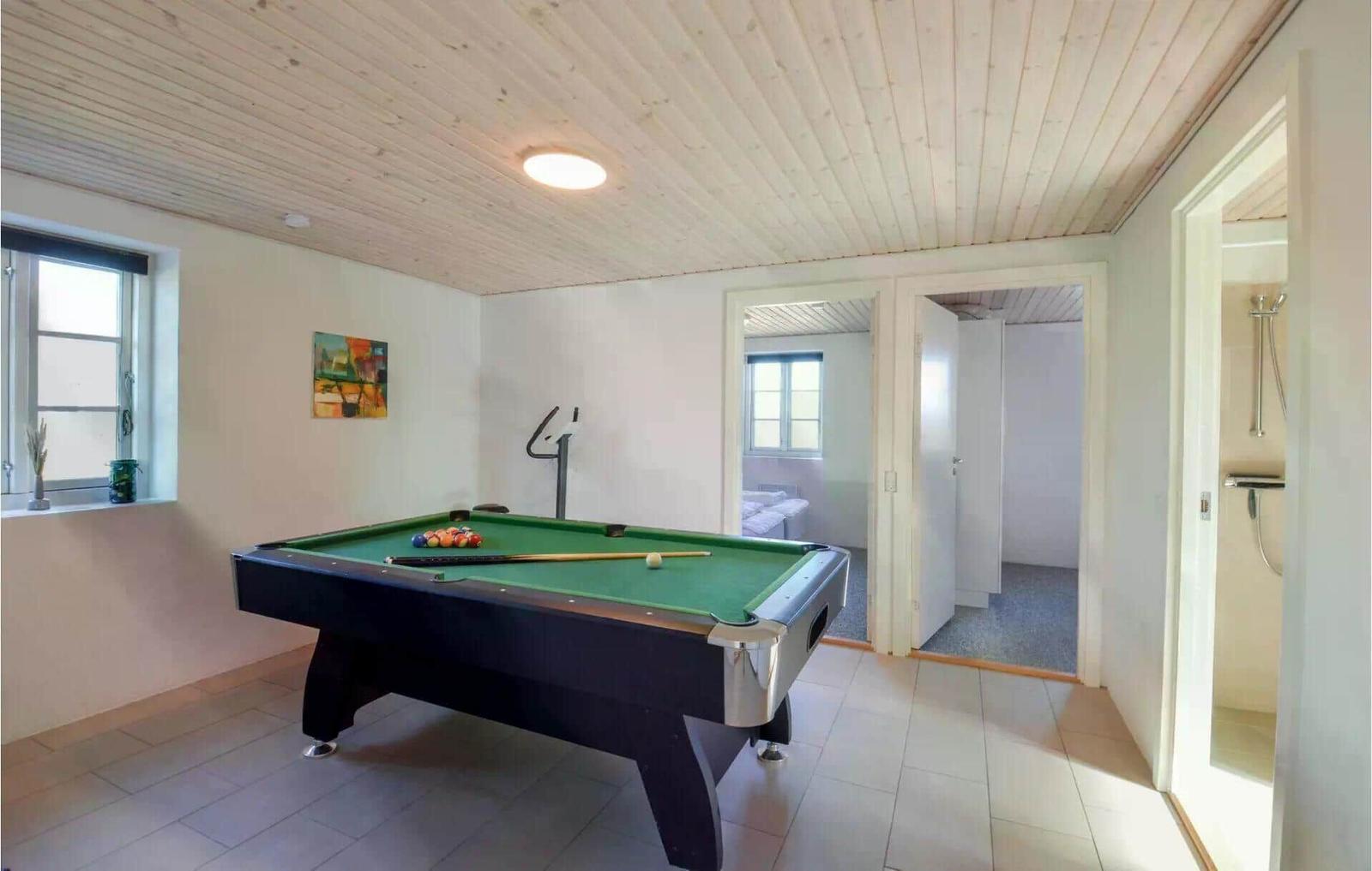 Raum mit Billardtisch, Fitnessgerät und Blick in angrenzende Räume.