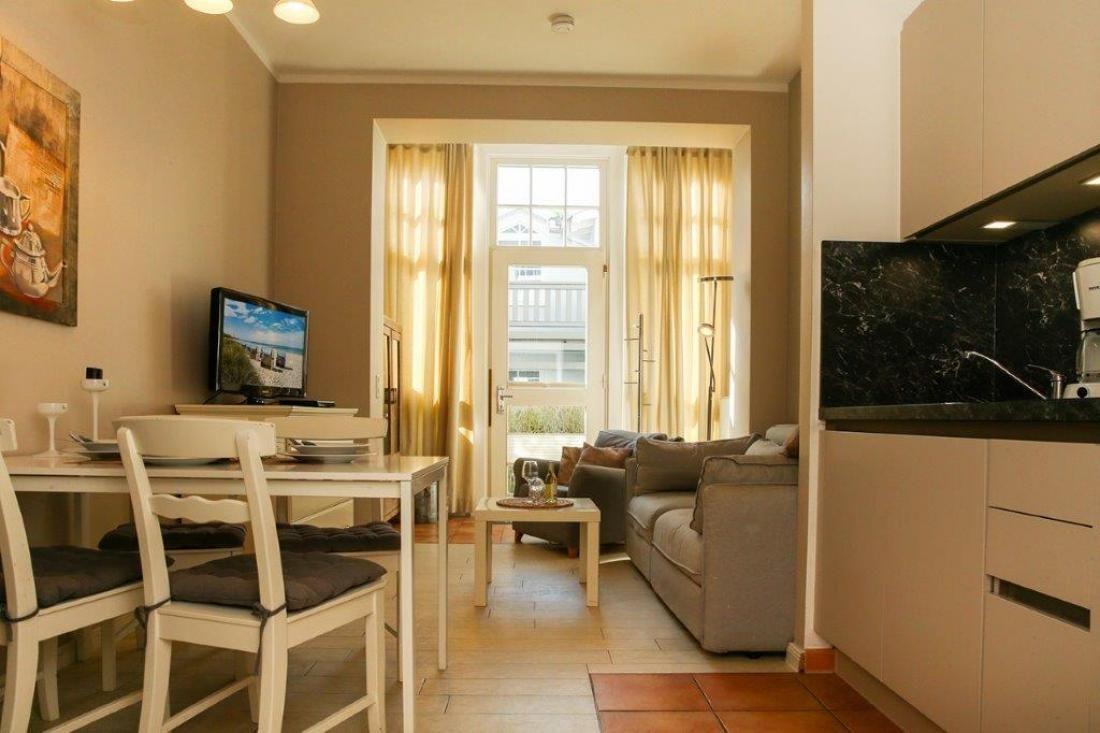 Wohnung mit Essbereich, Küche und Wohnzimmer mit Blick auf Balkon.