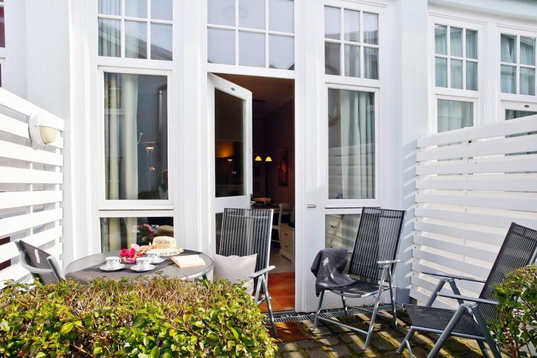 Terrasse mit Tisch, Stühlen und Blick ins Haus