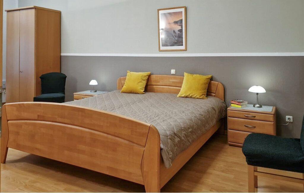 Schlafzimmer mit Holzbett, Nachttischen und Kleiderschrank.