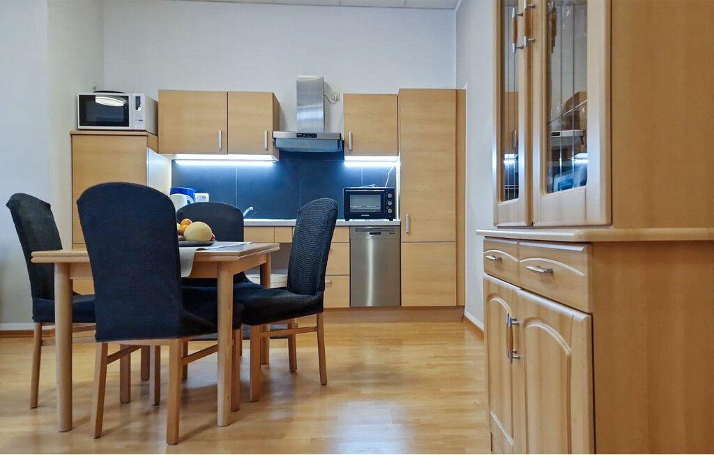 Küche mit Essbereich, Holzmöbel und Edelstahlgeräten.