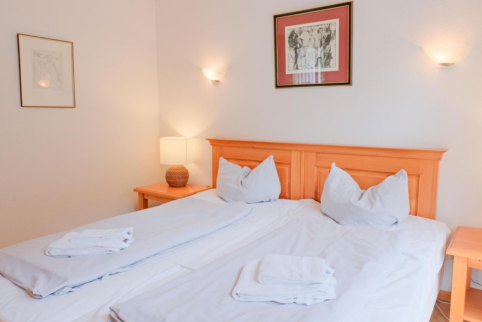 Ein Schlafzimmer mit Bett, Nachttisch und Wandlampen.