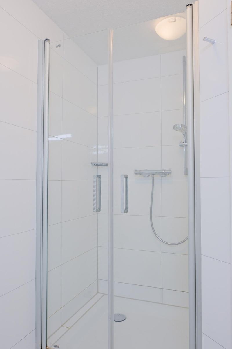 Duschbereich mit Glaswand und Duschkopf