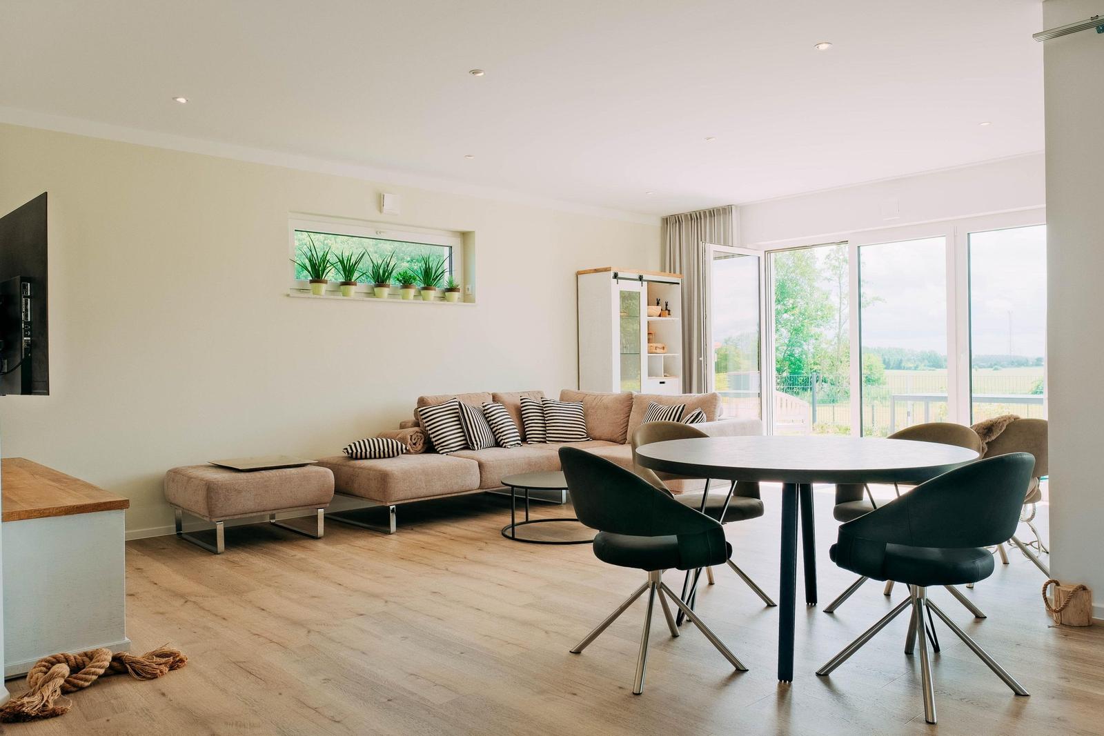 Wohn- und Essbereich mit Sofa, Esstisch und Blick auf die Terrasse.