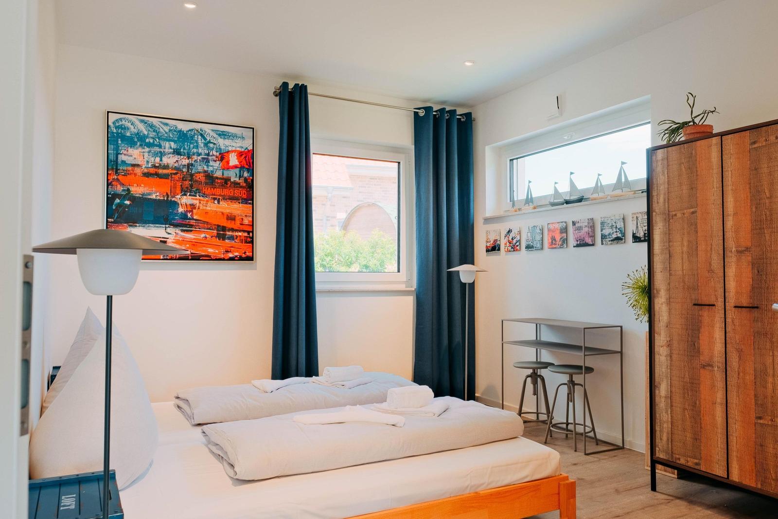 Schlafzimmer mit Bett, Kleiderschrank und Fenster mit Blick.