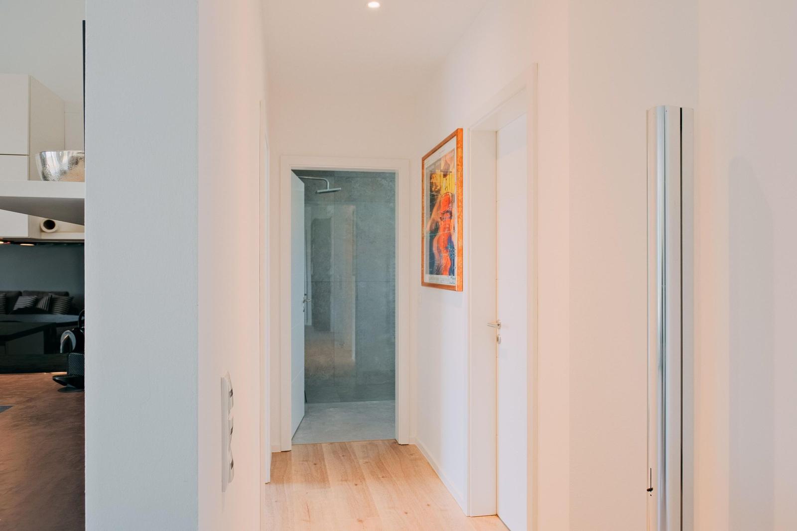 Flur mit Holzboden, Badezimmer und Wandbild