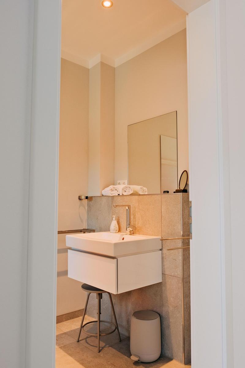 Badezimmer mit Waschbecken, Spiegel und Handtüchern