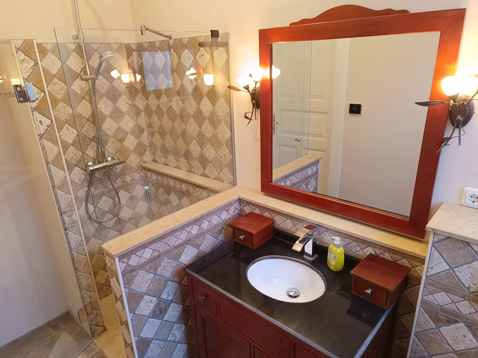 Bad mit Dusche, Waschbecken und Spiegel