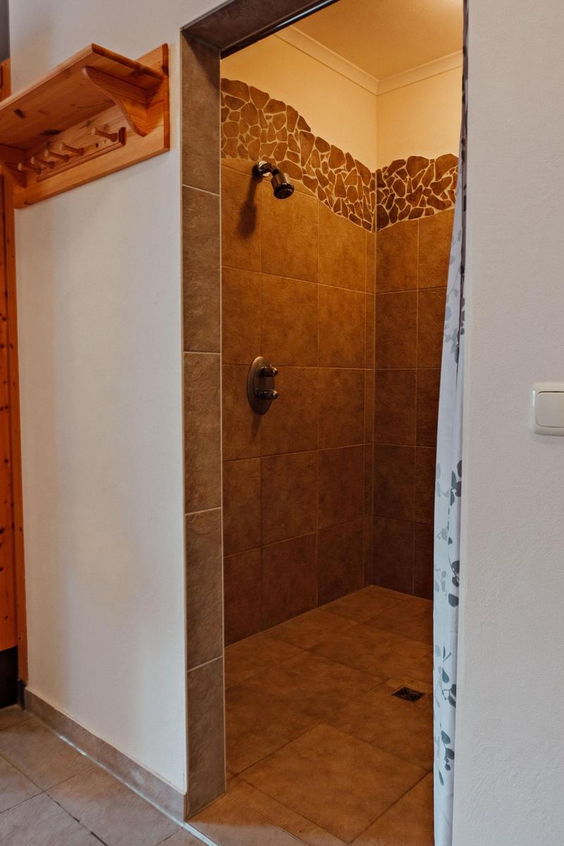 Dusche mit Steinverkleidung und Duschbrause