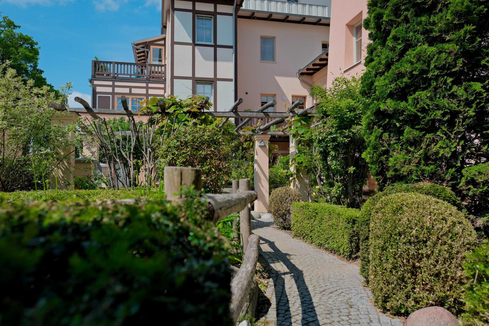 Steinweg durch grünen Garten zur Ferienwohnung