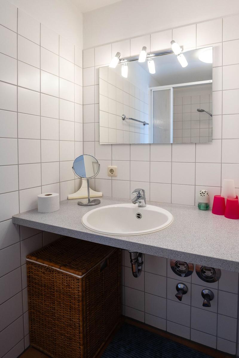 Badezimmer mit Waschbecken, Spiegel und Dusche