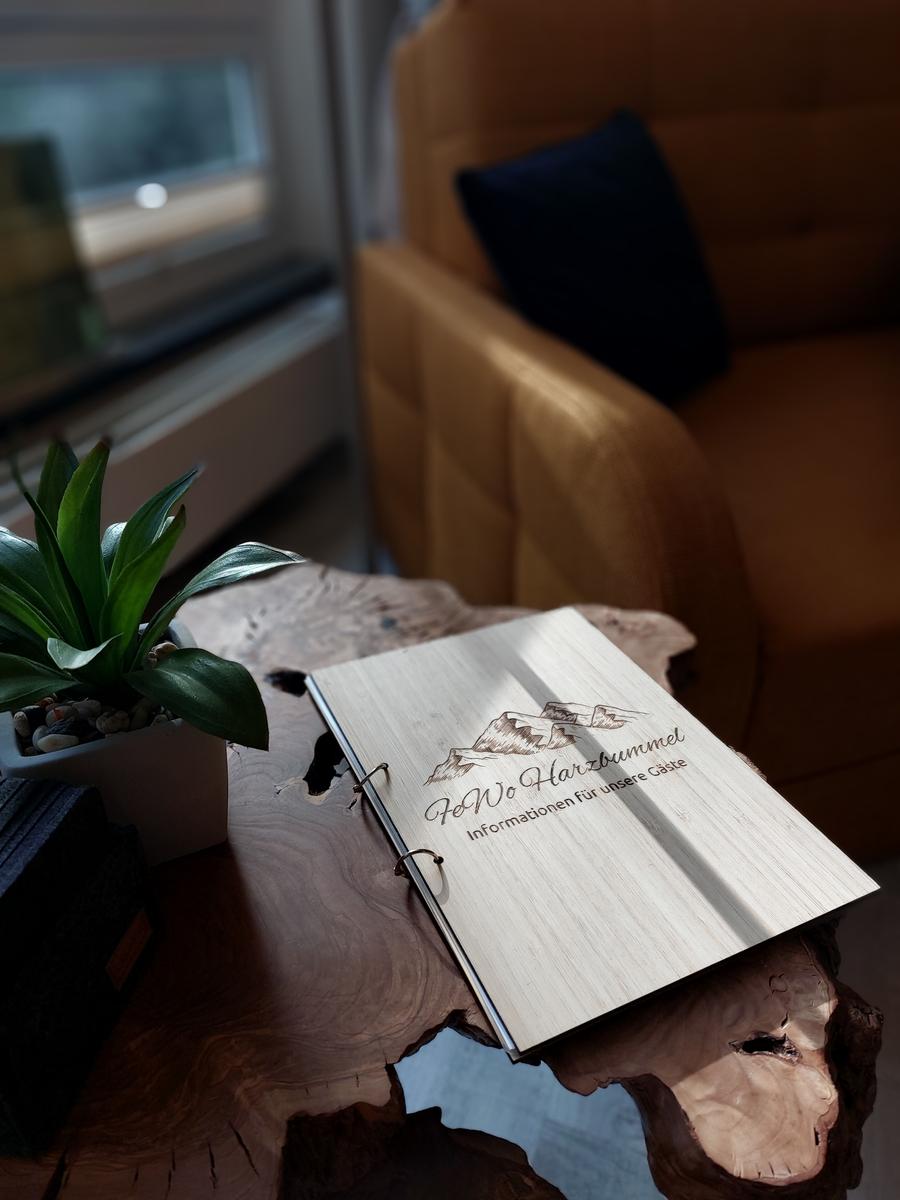 Holztablett mit Informationsbuch und Pflanze im Wohnbereich