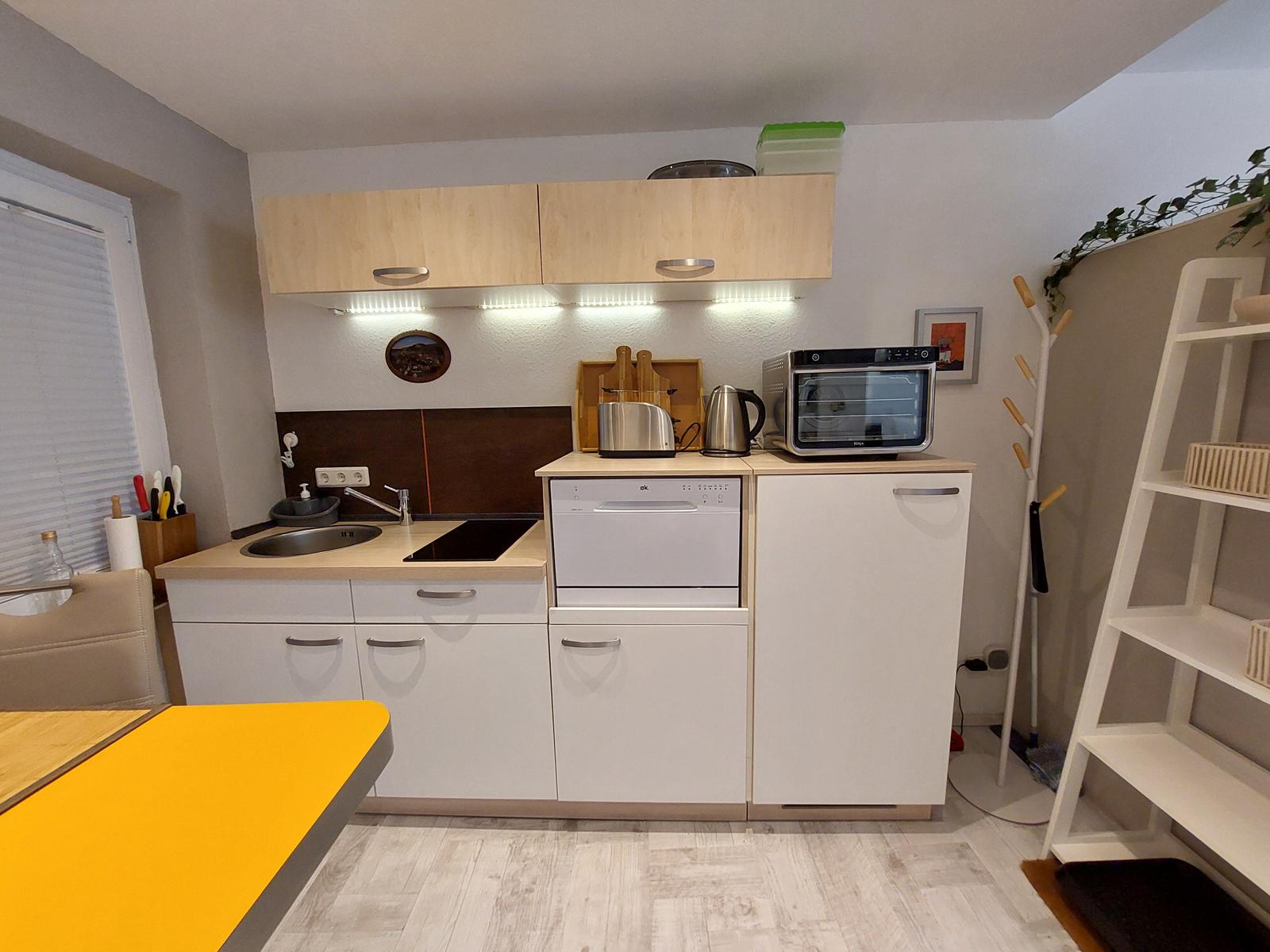 Küche mit Arbeitsplatte, Spüle, Herd und Geschirrspüler.