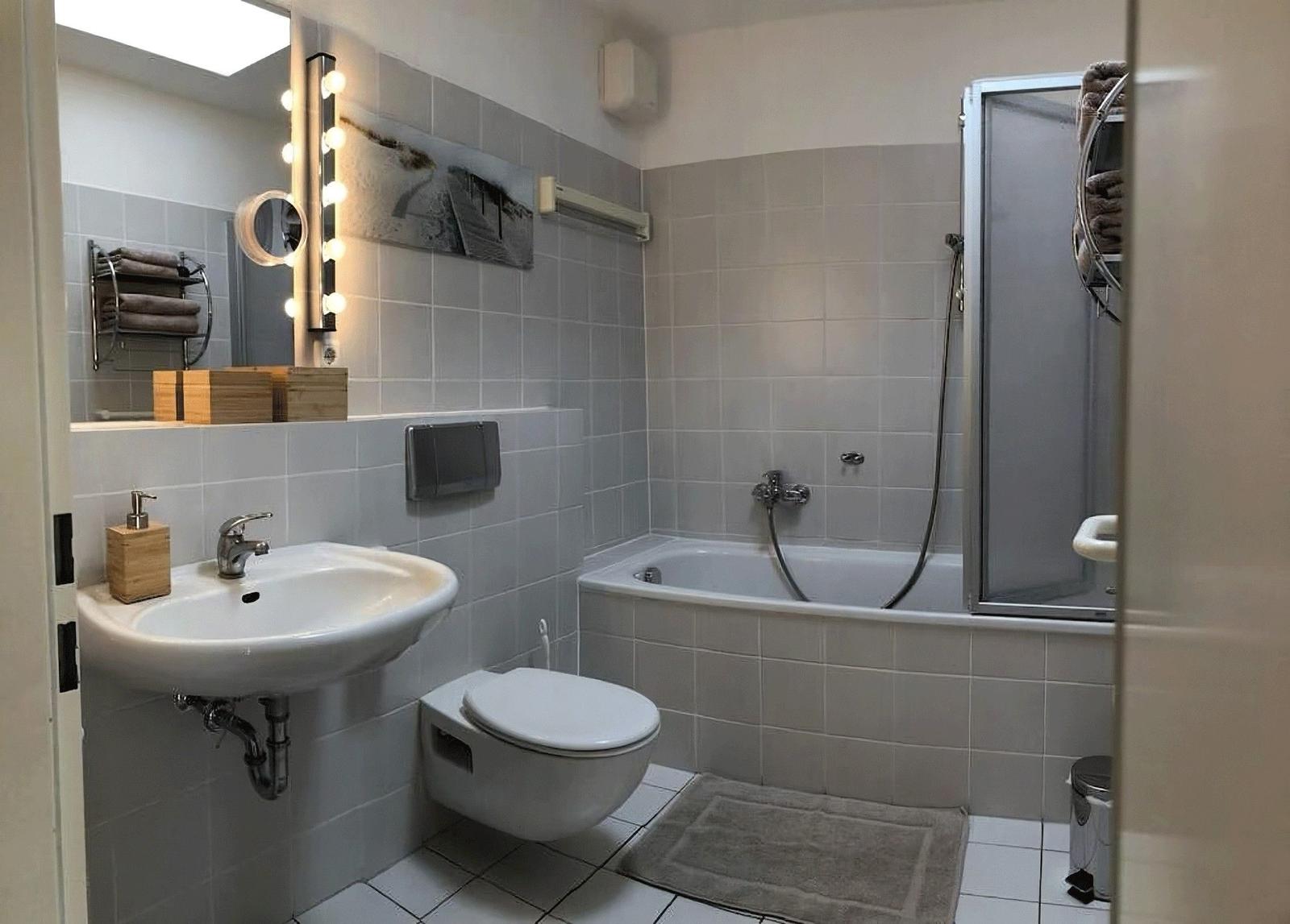 Badezimmer mit Badewanne, Dusche, Waschbecken und Toilette.