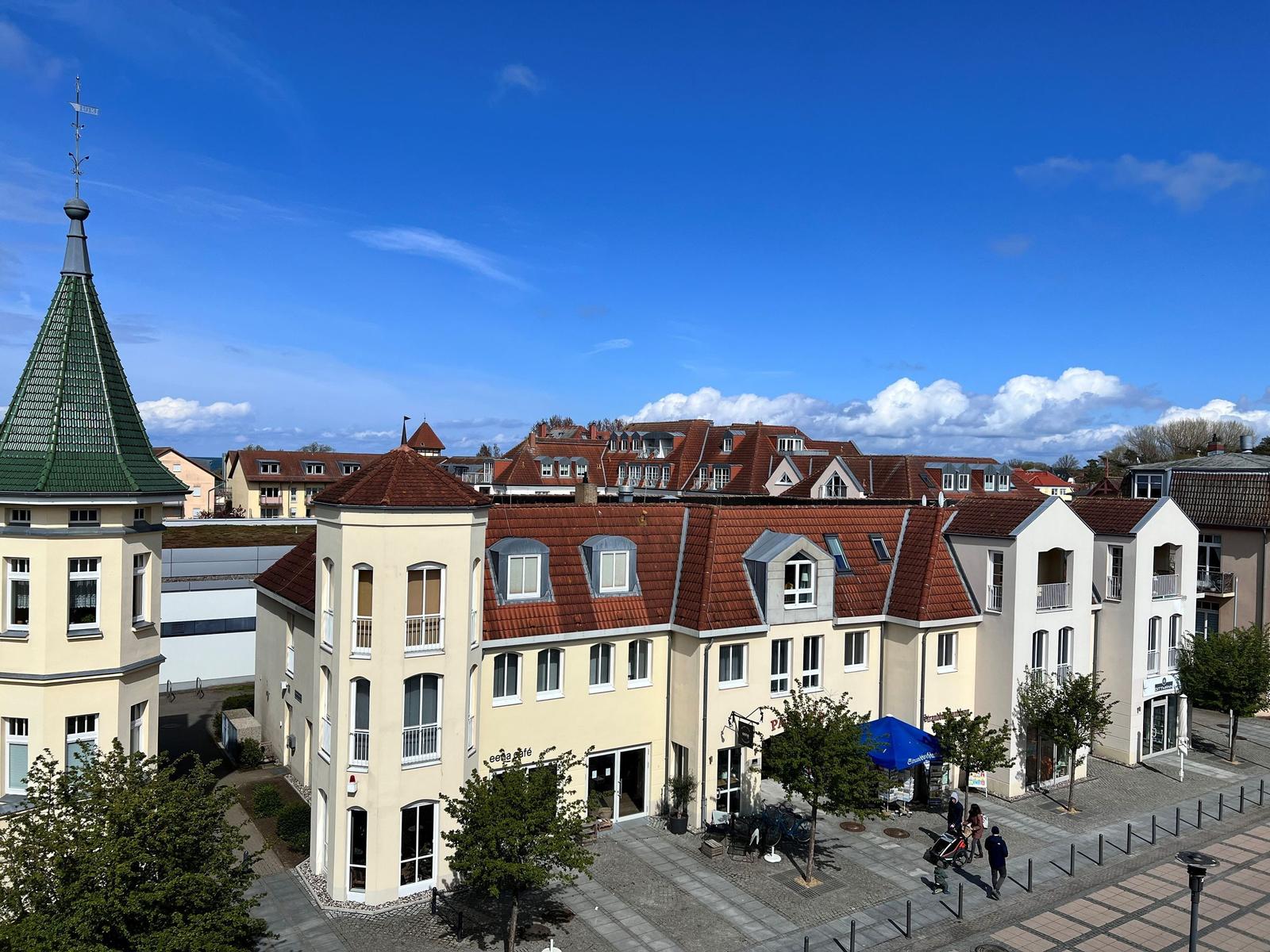 Stadtansicht mit Gebäuden, Dächern und blauem Himmel.