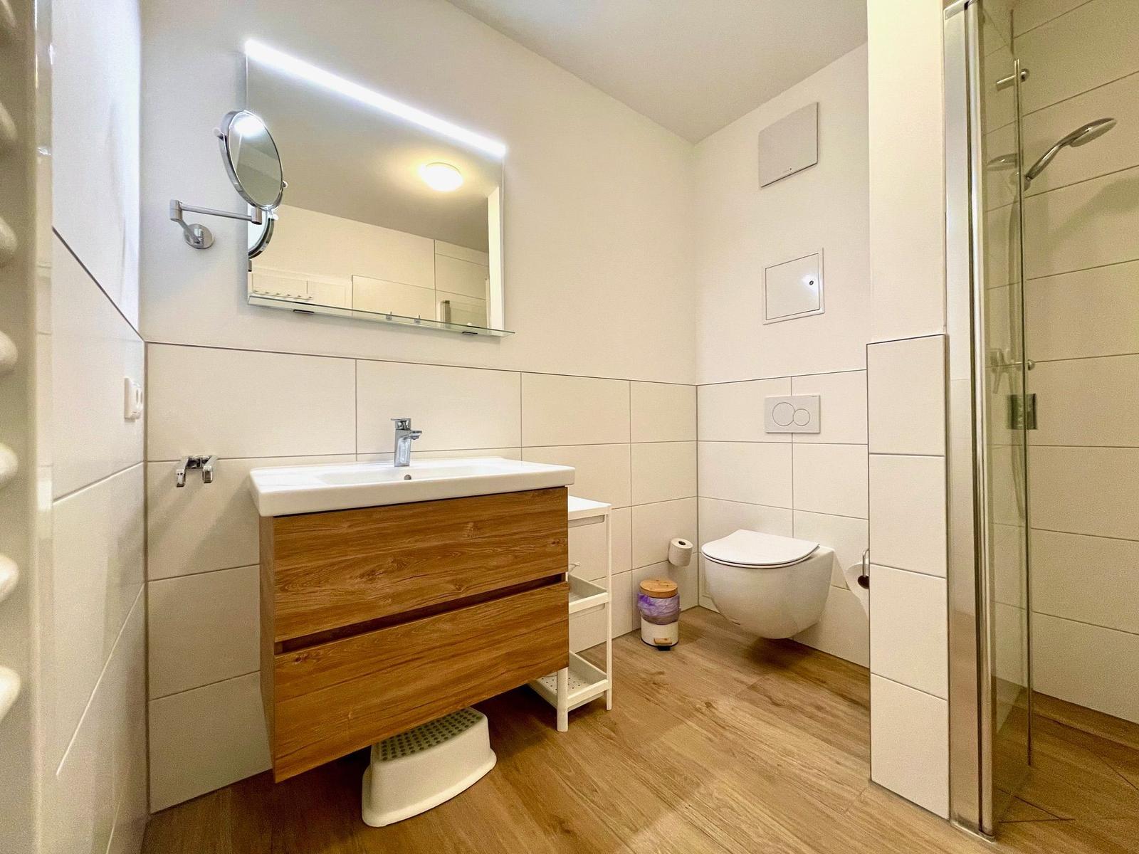 Badezimmer mit Dusche, Waschbecken und Toilette.