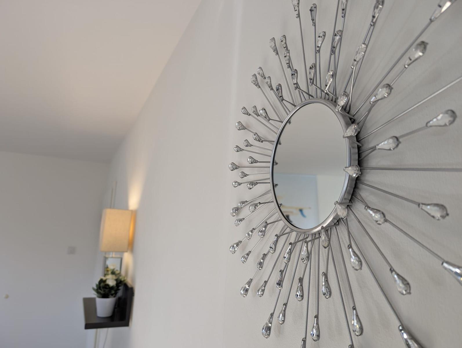 Sonnige Wanddekoration mit Spiegel und Kristallapplikationen
