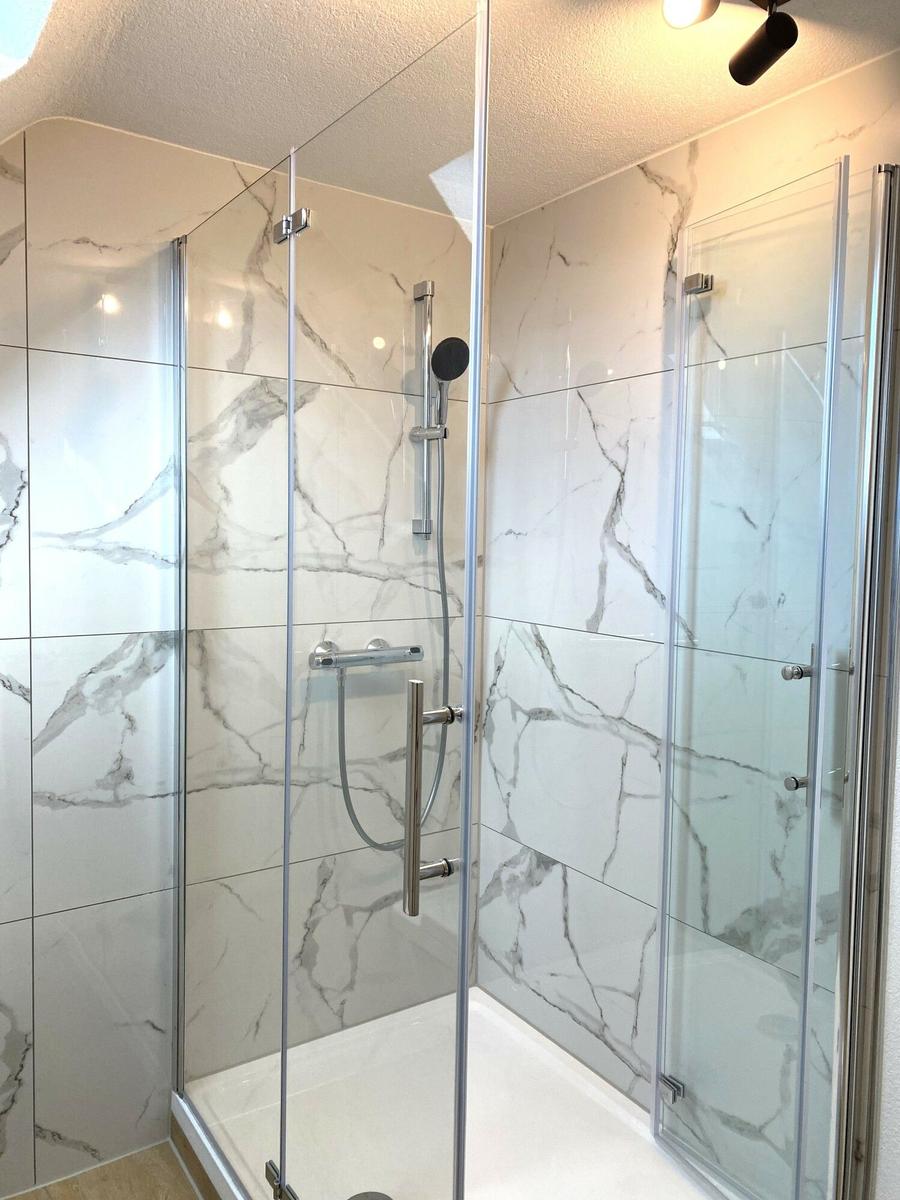 Duschkabine mit Glaswand und Marmorfliesen
