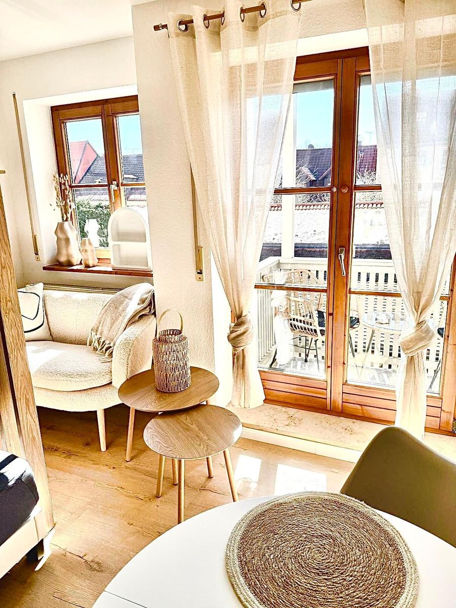 Wohnbereich mit Sitzgelegenheit, Tisch und Balkonzugang.