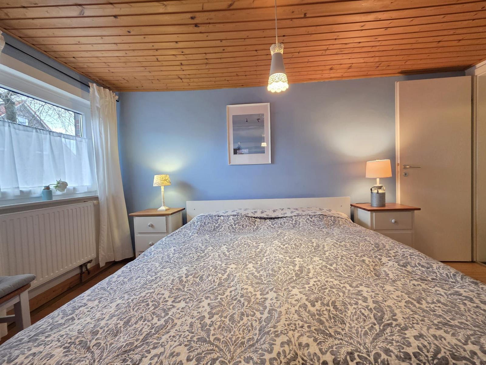 Bedroom with bed, nightstands, and window.