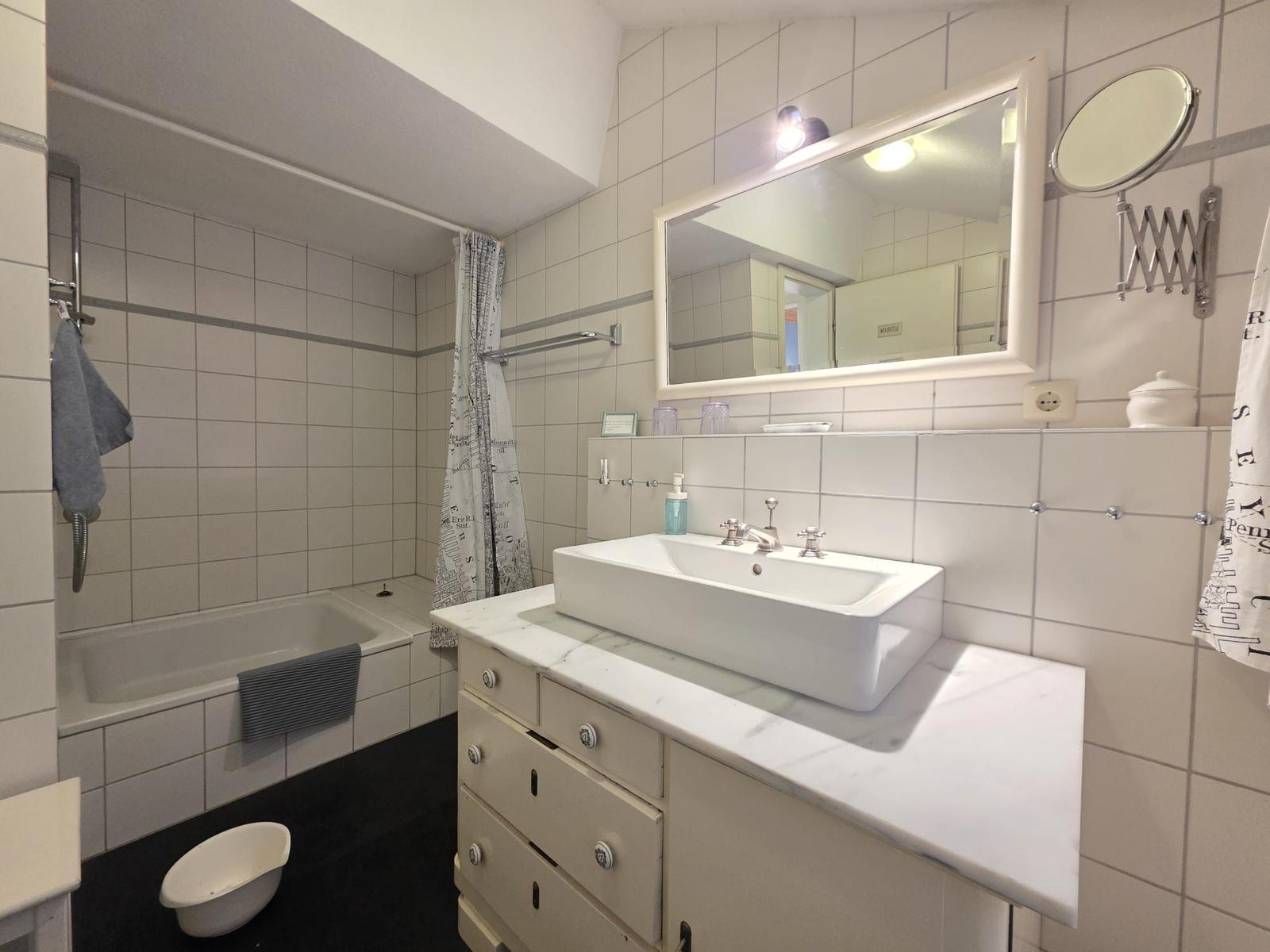 Bathroom with bathtub, sink, and mirror