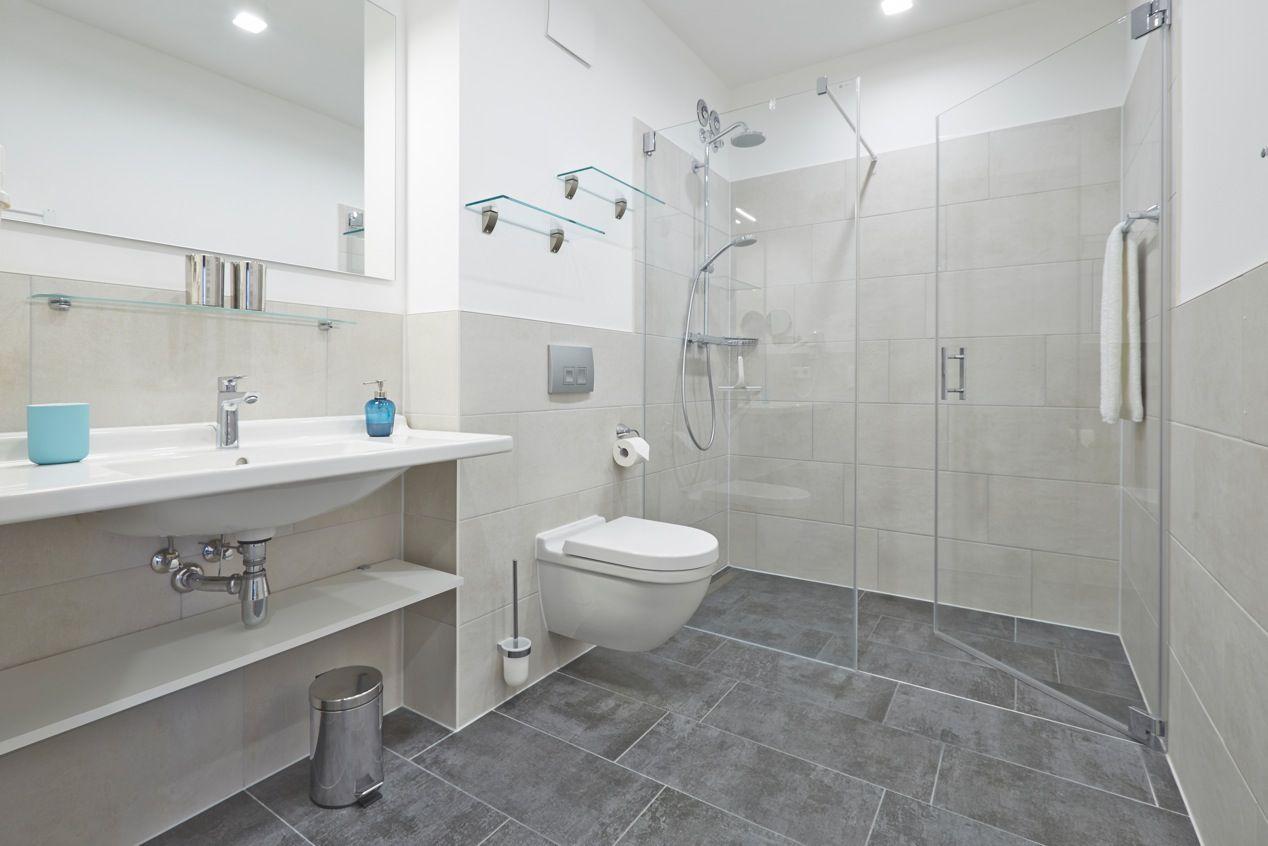 Badezimmer mit Dusche, Waschbecken und WC.