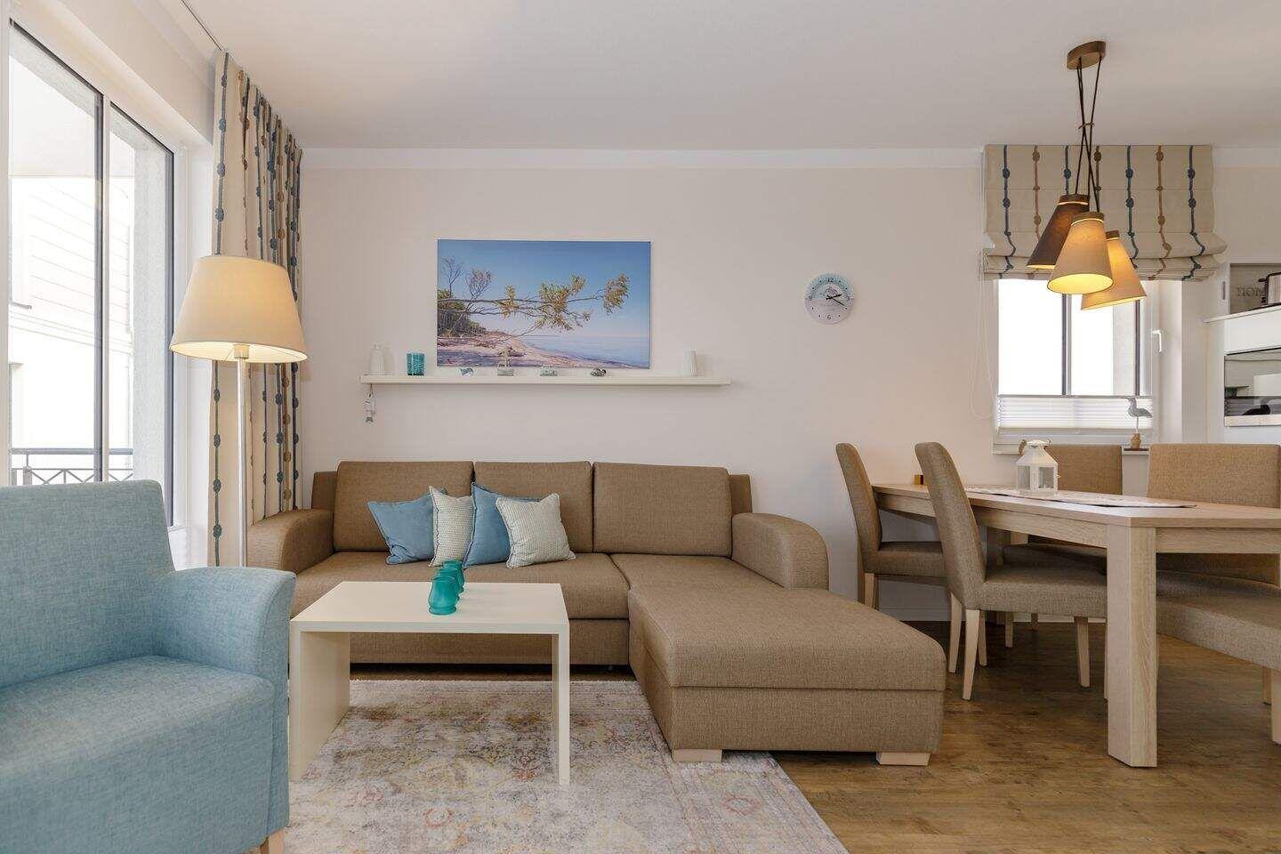 Wohn- und Essbereich mit Sofa, Tisch und Stühlen.