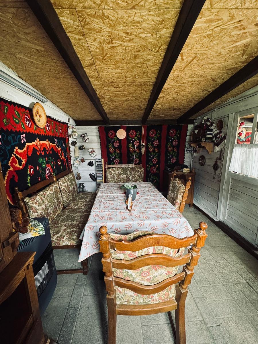 Esszimmer mit Holzstühlen, Tisch und Wandteppichen