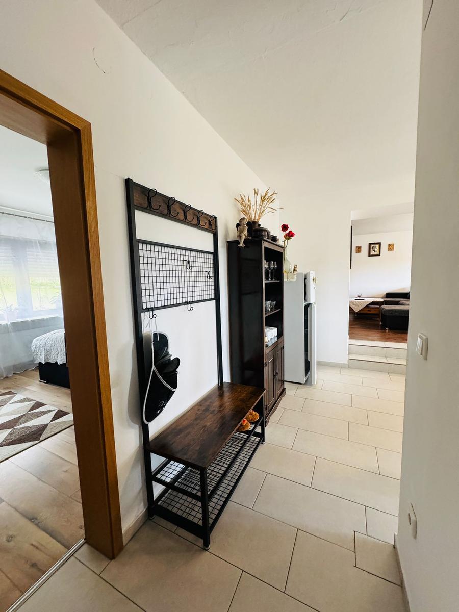 Eingangsbereich mit Garderobe, Bänke und Blick in Wohn- und Schlafzimmer.