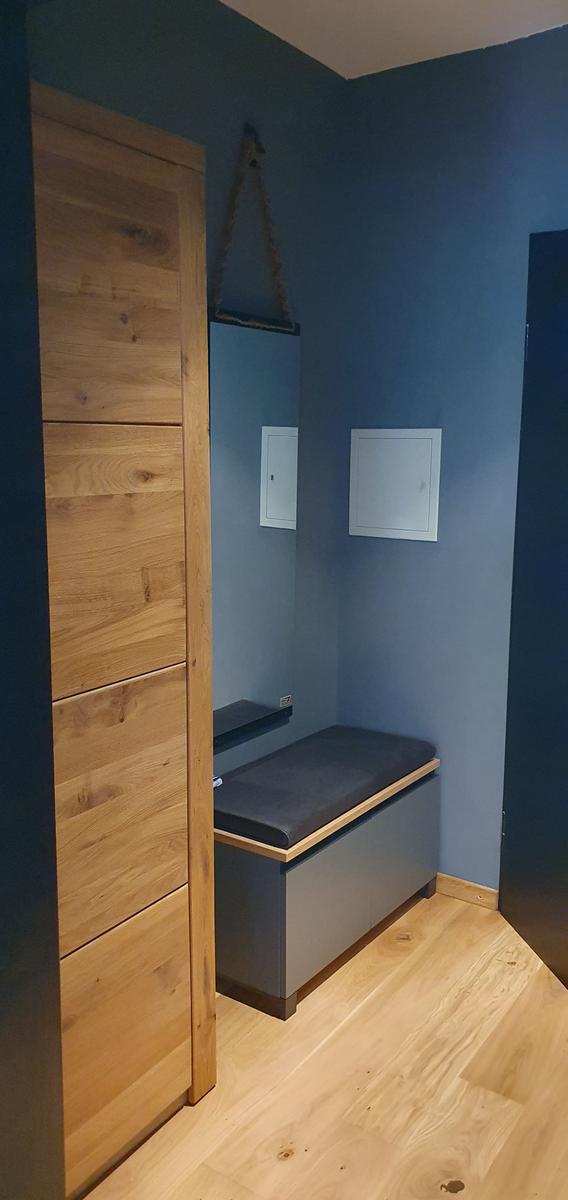 Schlafzimmer mit Holzschrank und Sitzbank an der Wand
