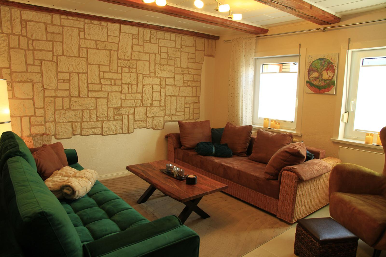 Wohnzimmer mit Schlafsofa und grünem Samtsofa