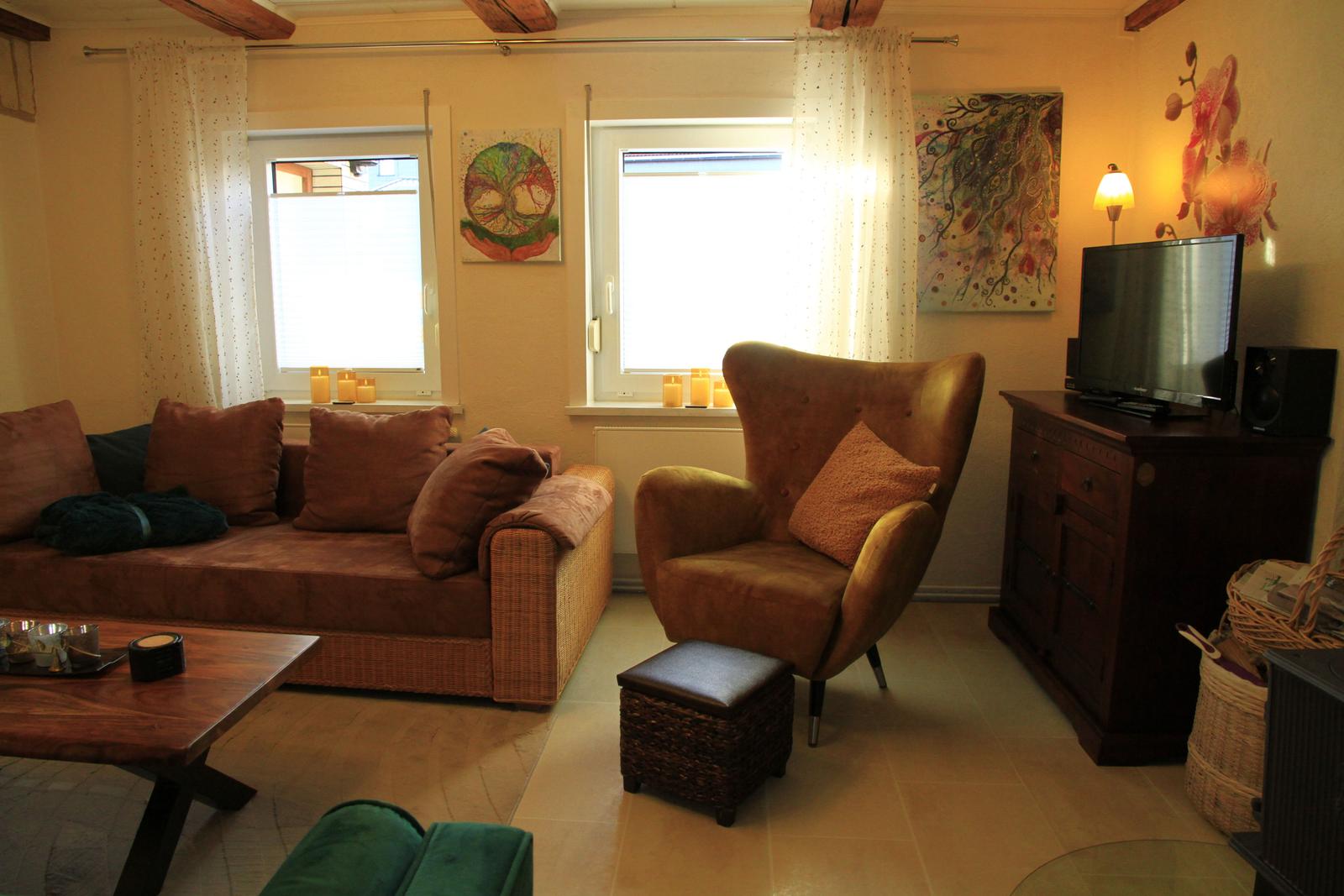 Wohnzimmer mit Tageslicht und samtgelbem Ohrensessel