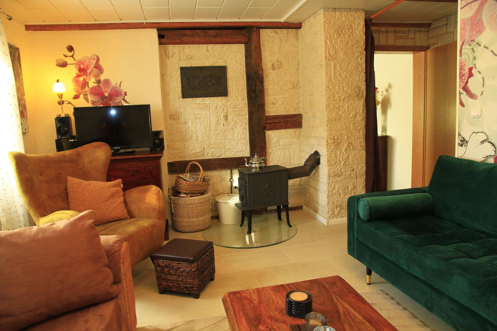 Wohnzimmer mit skanidavischem Holzofen, TV und Musikanlage