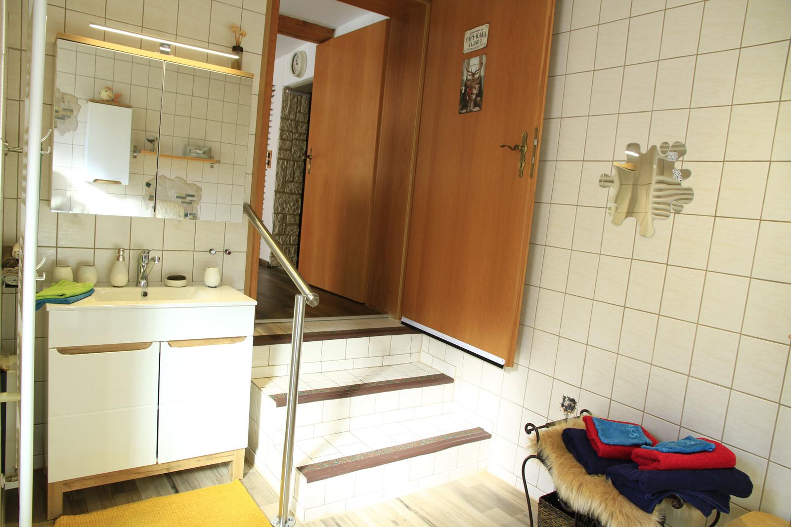 Badezimmer, es führen 3 Stufen von der Küche ins Badezimmer mit Doppeltür