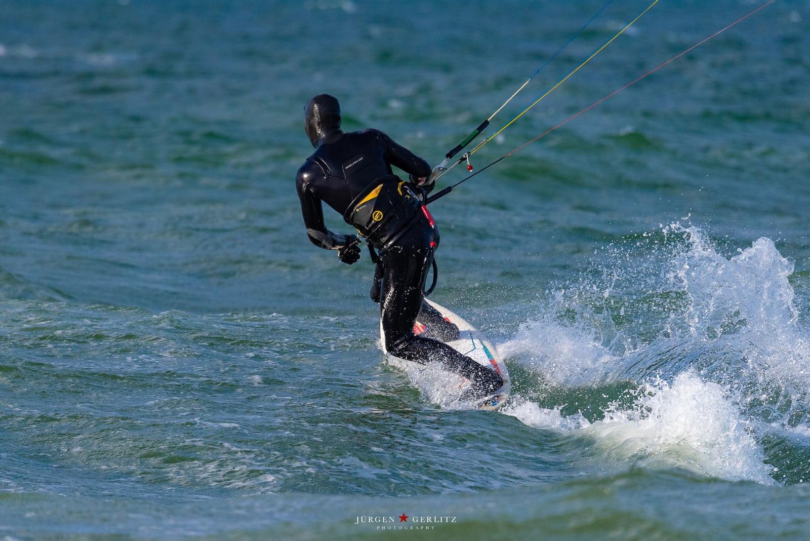 Kitesurfer auf dem Wasser mit Board und Steuerungsschnur.