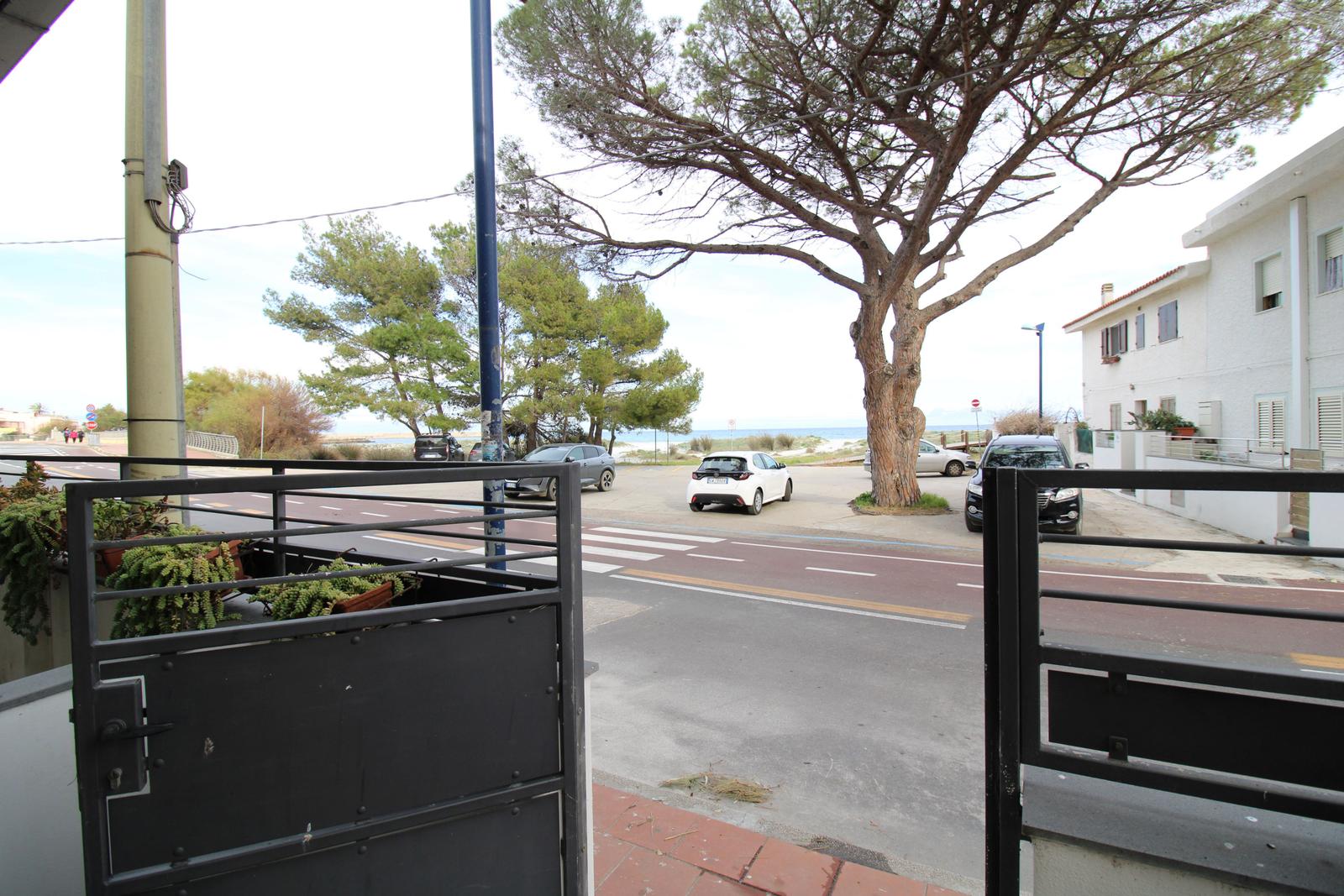 Von der Terrasse aus sieht man die Straße, Bäume und das Meer.