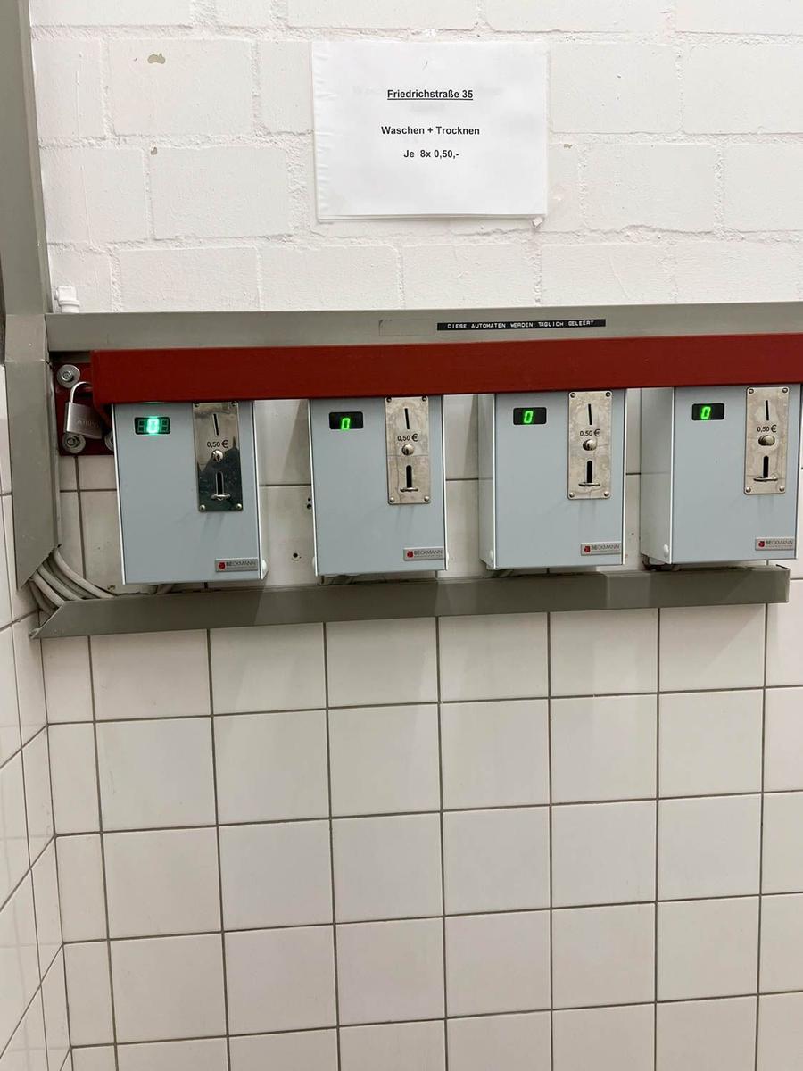 Wasch- und Trocknerautomaten mit Preisangaben an der Wand