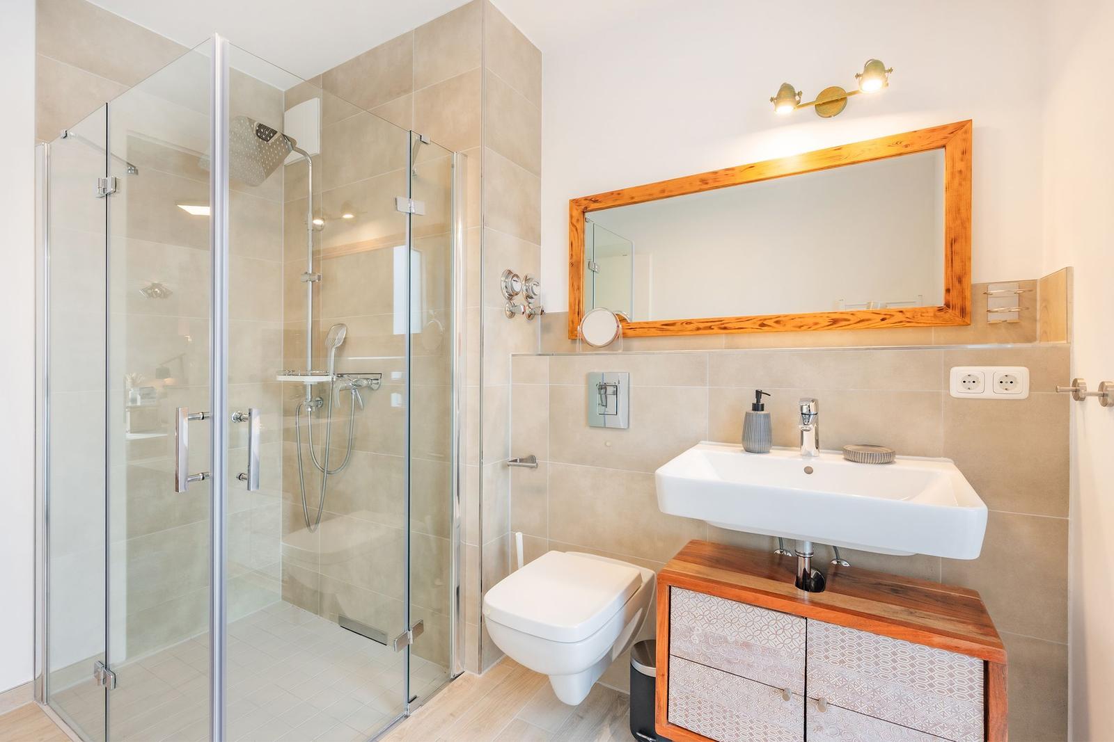 Badezimmer mit Dusche, Waschbecken und Toilette.
