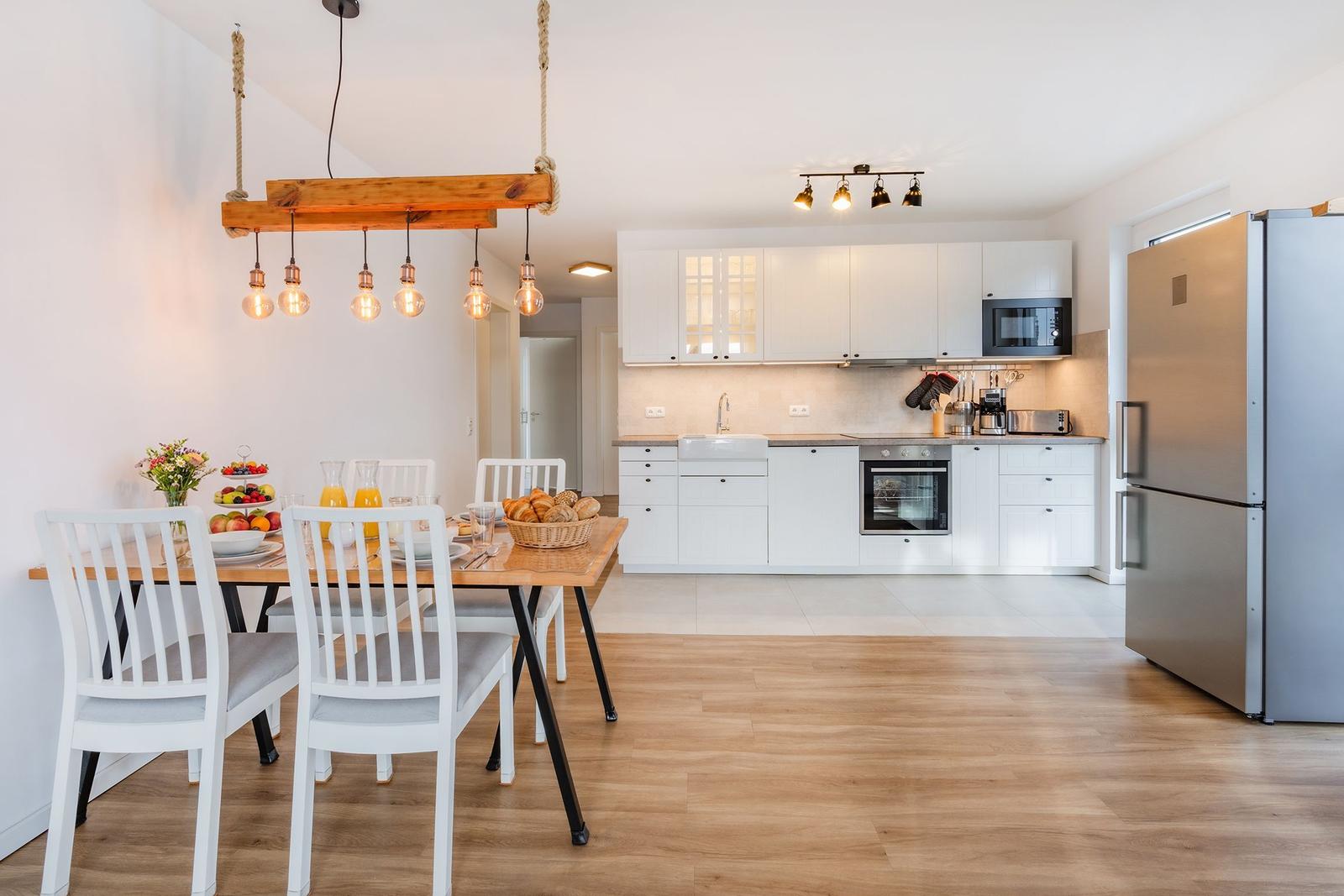 Küche mit Esstisch, Kühlschrank und Kochgeräten.