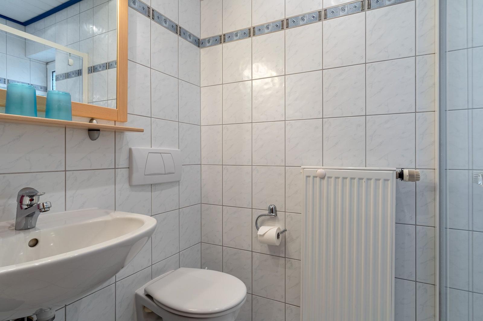 Badezimmer mit Waschbecken, Toilette und Heizkörper