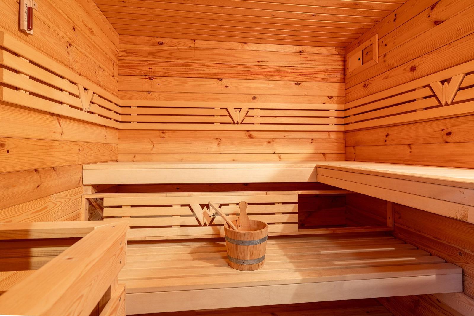 Sauna mit Holzbank und Eimer mit Kelle