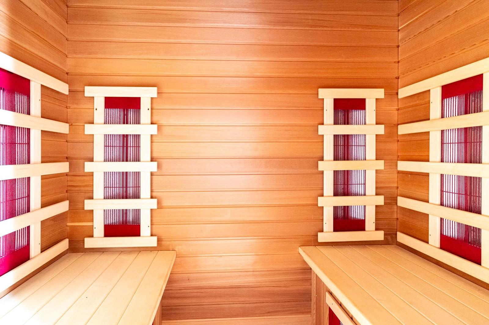 Sauna mit Holzwand und Sitzbänken mit roten Schiebegittern