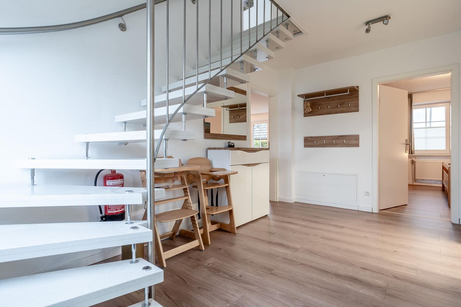 Moderne Wohnung mit Treppe, Essbereich und Eingangsbereich.