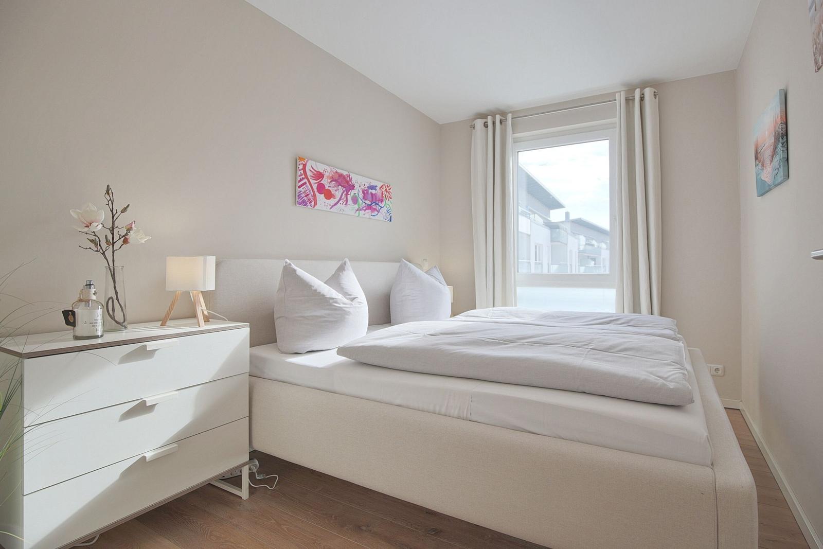 Schlafzimmer mit Doppelbett, Nachttisch und Fenster