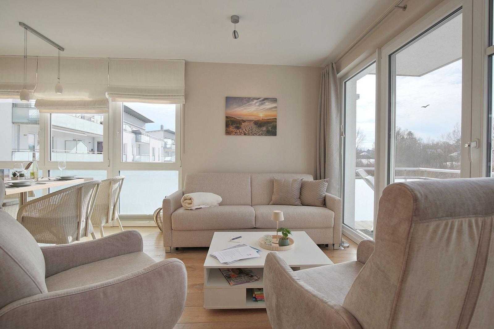 Wohn- und Essbereich mit Sofa, Sessel und großem Fensterblick.