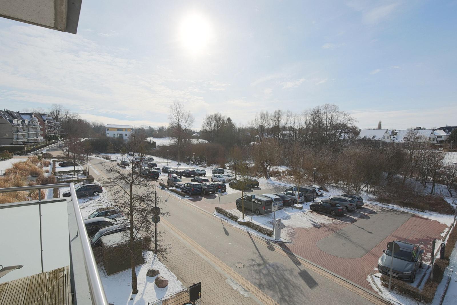 Aussicht auf Parkplatz mit Autos und verschneite Bäume
